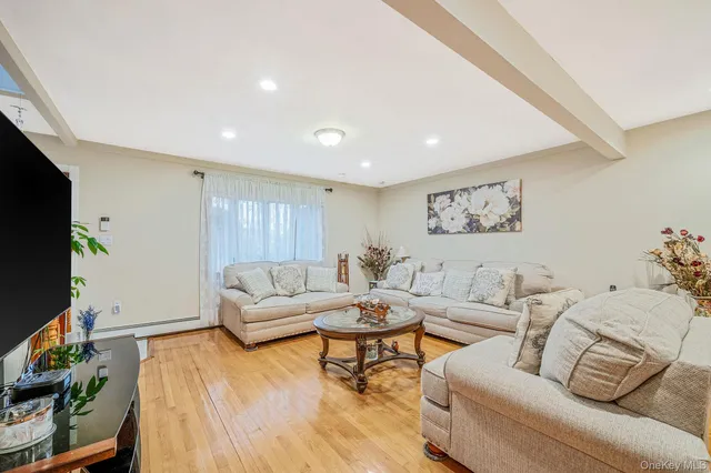 a living room with furniture a flat screen tv and a window