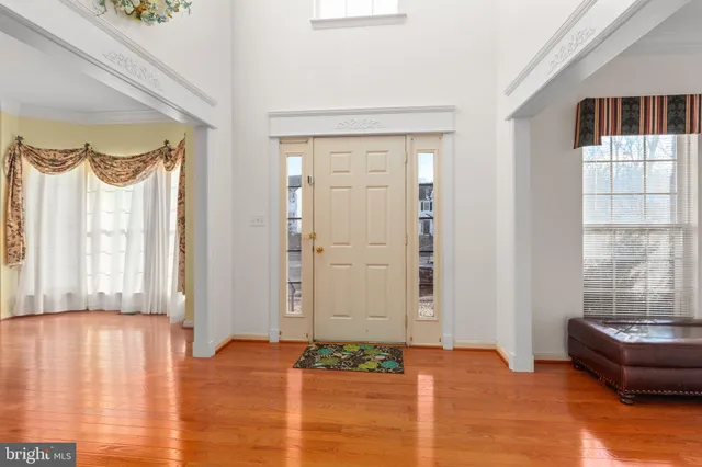 a view of an empty room with kitchen and a window