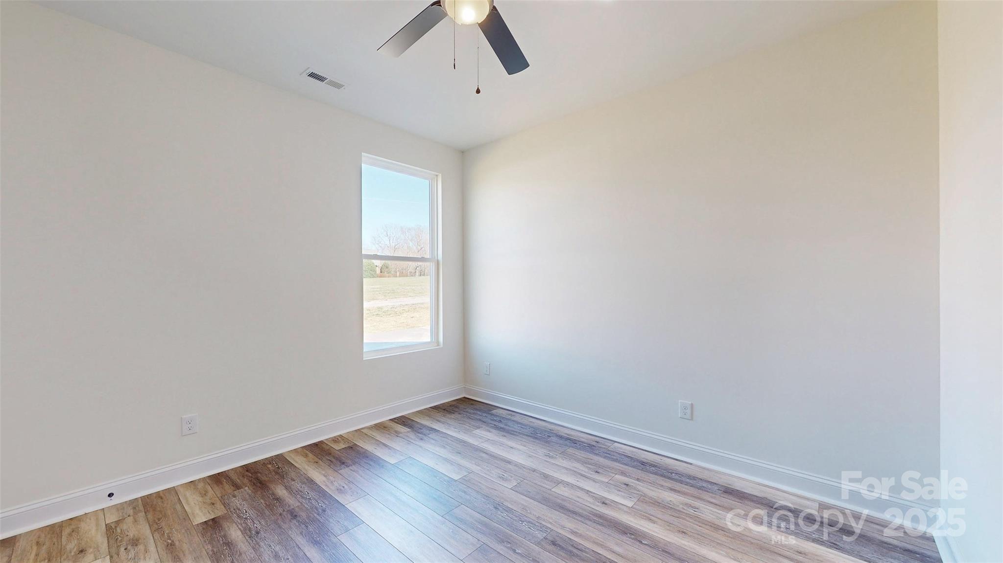 2906 Lathan Road Monroe, NC 28112 - Photo 15 of 41 an empty room with wooden floor and windows