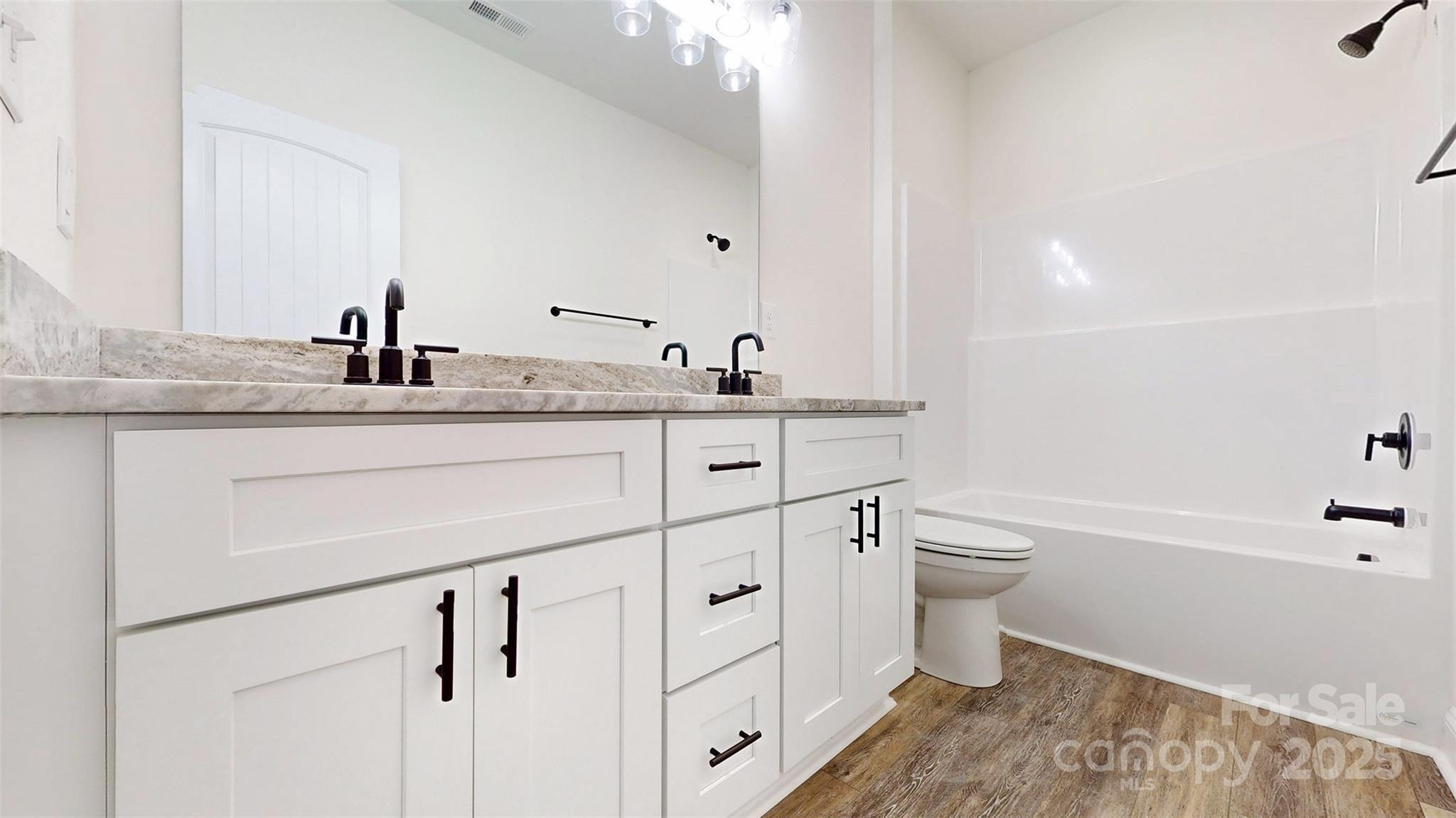 2906 Lathan Road Monroe, NC 28112 - Photo 16 of 41 a bathroom with a granite countertop sink a toilet and bathtub