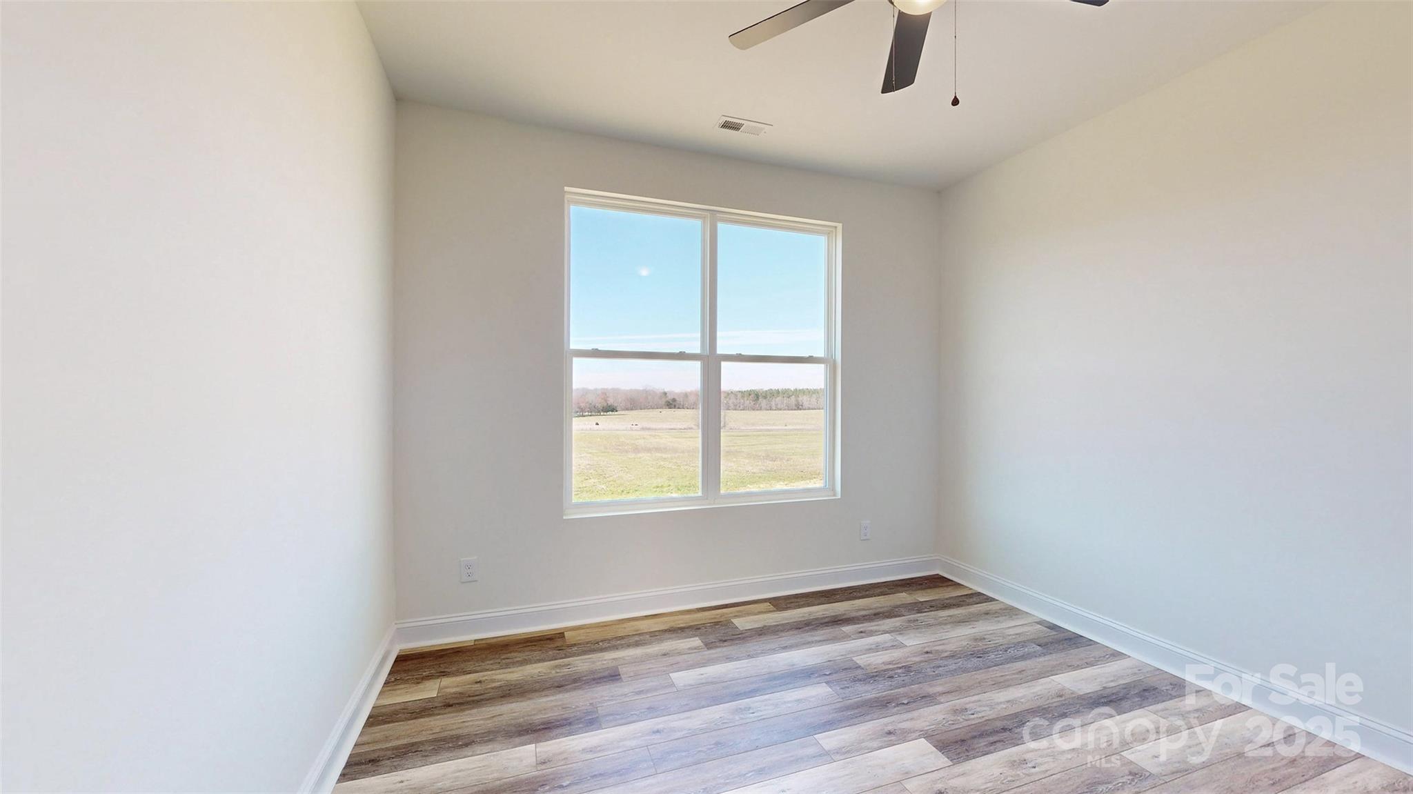 2906 Lathan Road Monroe, NC 28112 - Photo 18 of 41 an empty room with wooden floor and windows
