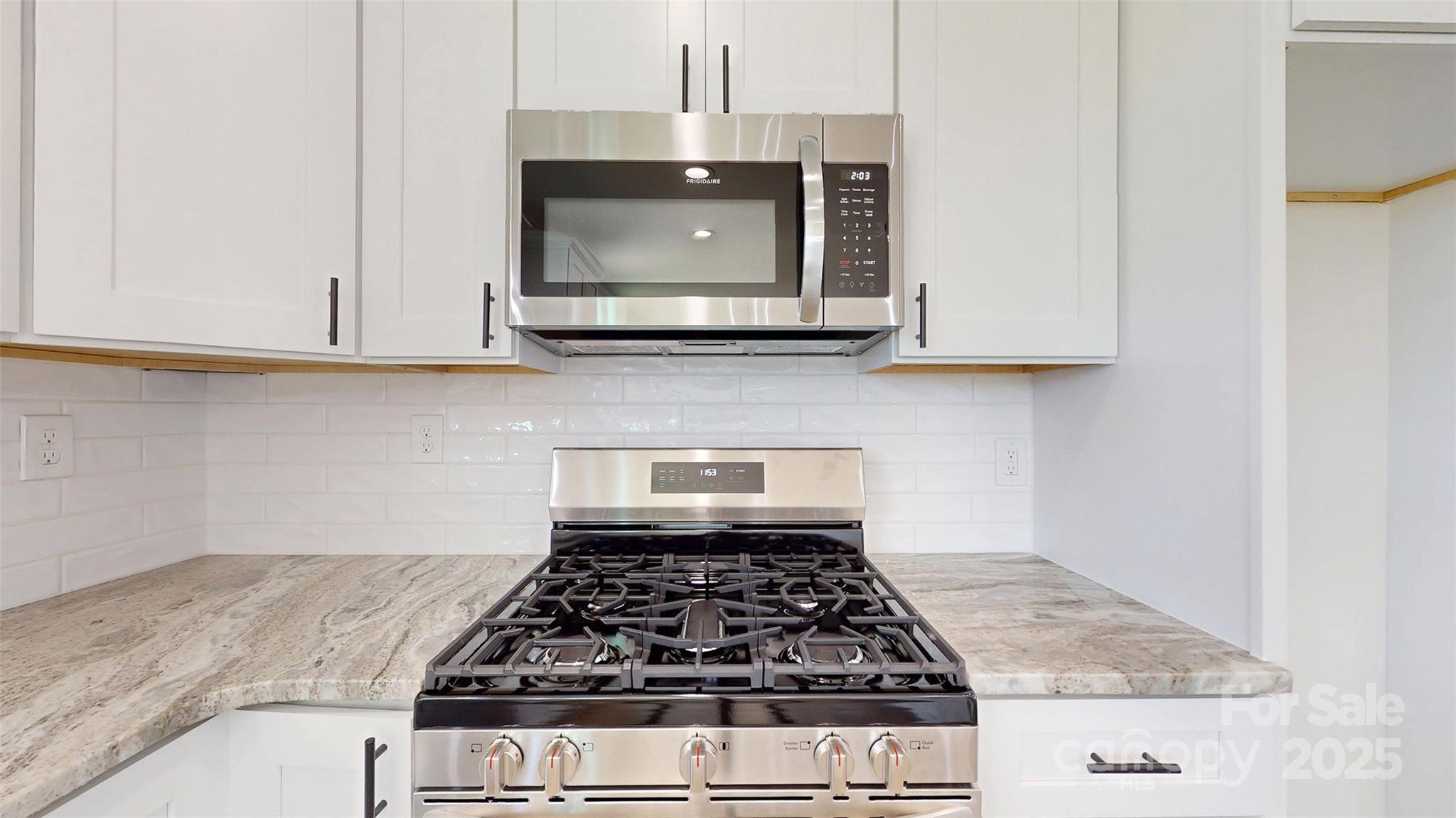 2906 Lathan Road Monroe, NC 28112 - Photo 21 of 41 a kitchen with granite countertop a stove a microwave cabinets and a sink