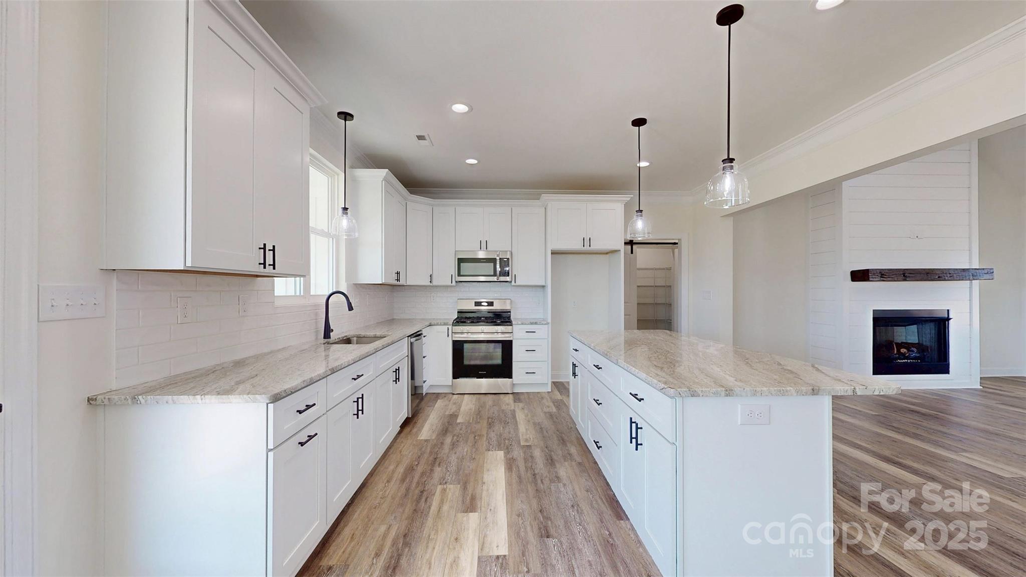 2906 Lathan Road Monroe, NC 28112 - Photo 24 of 41 a large kitchen with stainless steel appliances kitchen island granite countertop a sink and cabinets
