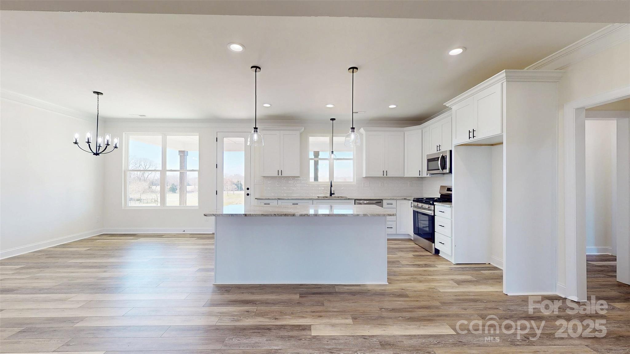 2906 Lathan Road Monroe, NC 28112 - Photo 30 of 41 a kitchen with kitchen island a sink a stove a refrigerator and white cabinets