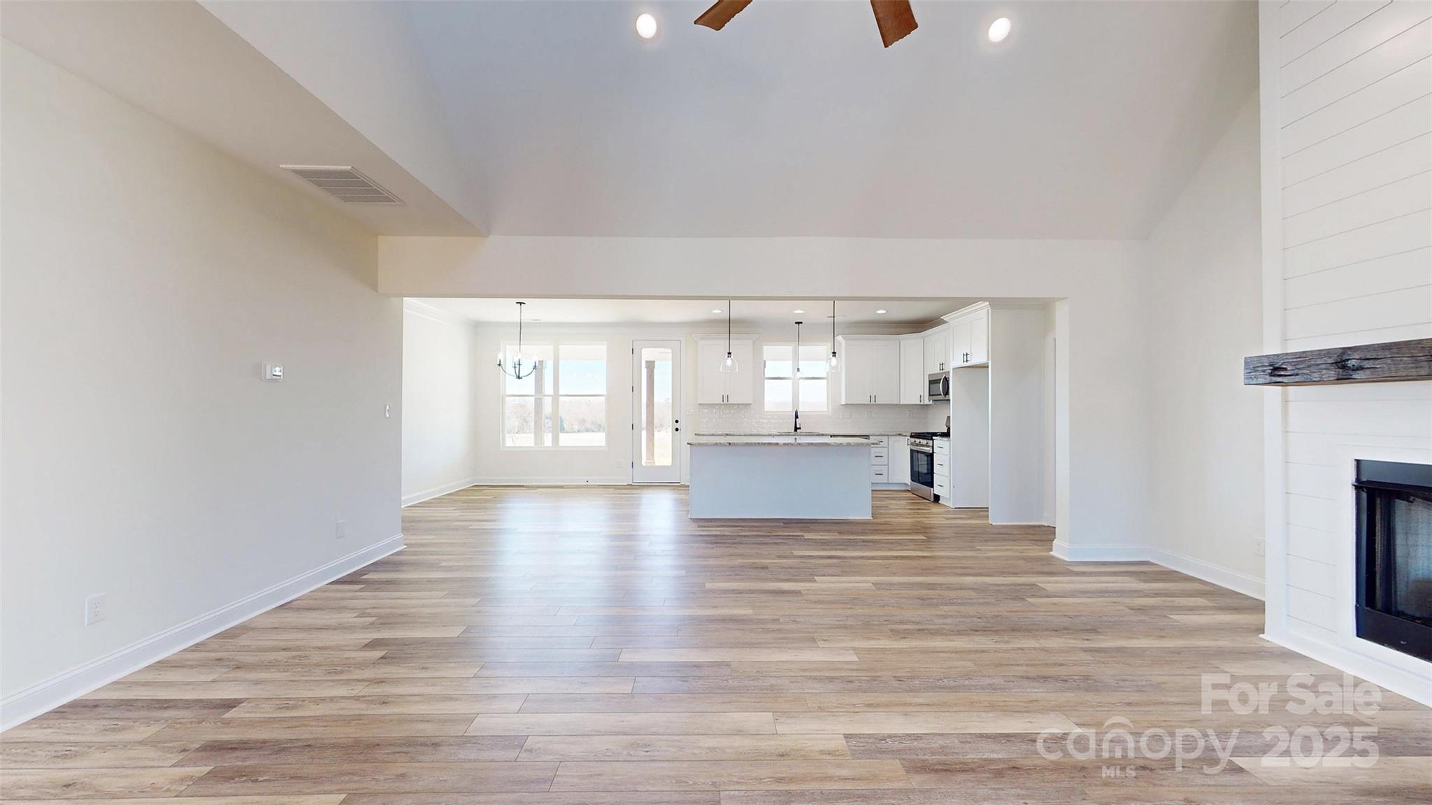 2906 Lathan Road Monroe, NC 28112 - Photo 31 of 41 a view of a kitchen with kitchen island a sink wooden floor and living room view