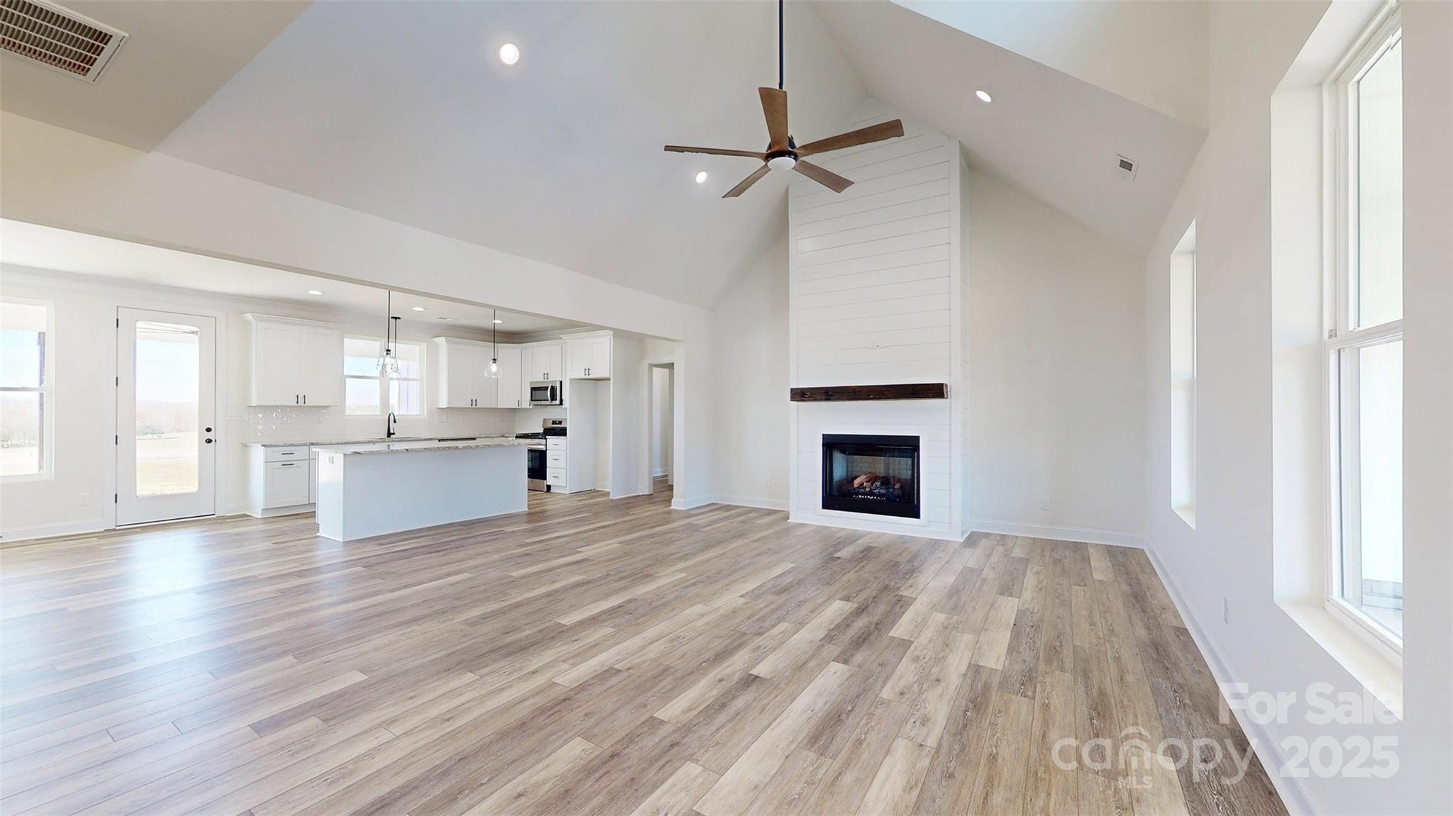 2906 Lathan Road Monroe, NC 28112 - Photo 34 of 41 a view of kitchen and empty room with wooden floor fireplace