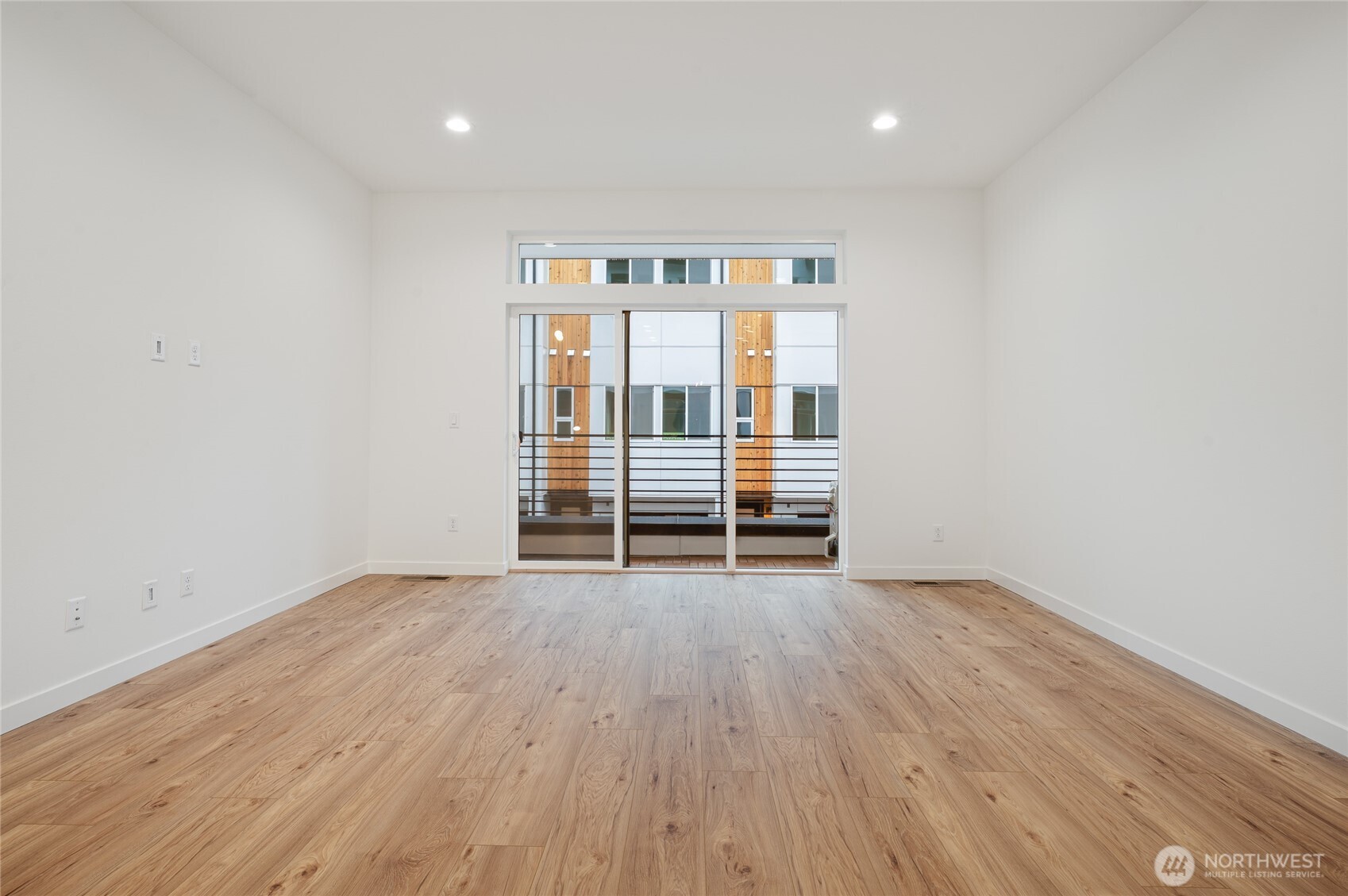1176 129th Avenue Southeast Bellevue, WA 98005 - Photo 6 of 32 an empty room with wooden floor and windows