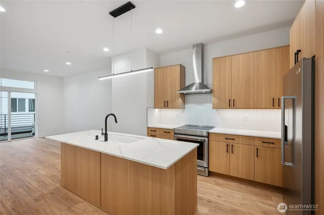 a large kitchen with granite countertop a sink and dishwasher a stove top oven with wooden floor