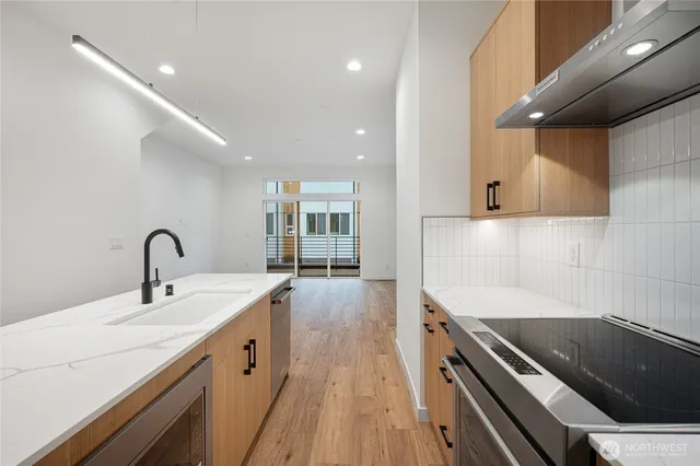 a kitchen with stainless steel appliances a sink stove and refrigerator