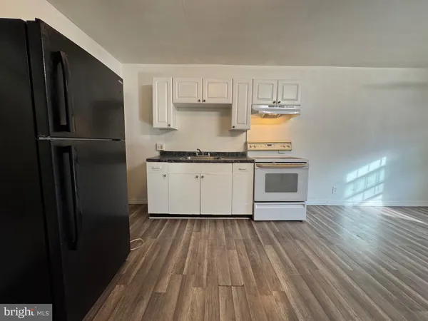 a kitchen with a sink wooden floor and stainless steel appliances