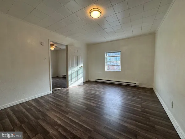 an empty room with wooden floor and window