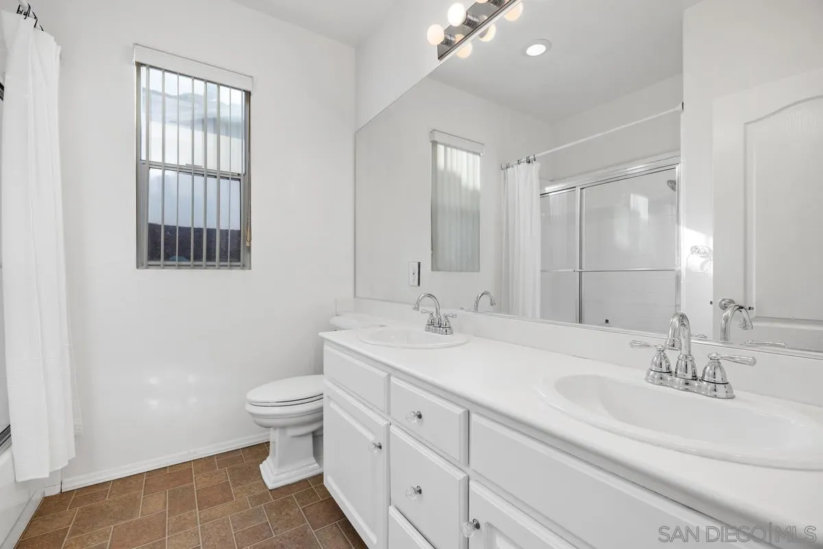 3643 Merced Drive Oceanside, CA 92056 - Photo 21 of 27 a bathroom with a double vanity sink toilet and a mirror
