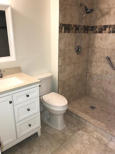 715 Caribou Drive Kissimmee, FL 34759 - Photo 12 of 13 a bathroom with a granite countertop toilet a sink a mirror and shower