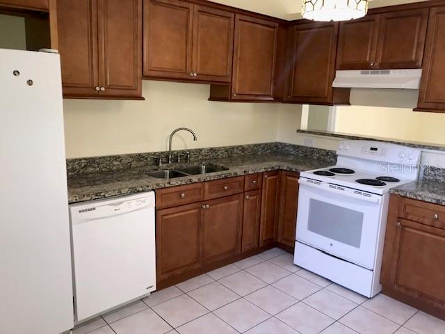 715 Caribou Drive Kissimmee, FL 34759 - Photo 6 of 13 a kitchen with granite countertop cabinets and steel stainless steel appliances