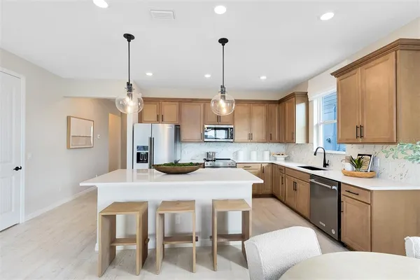 a kitchen with a stove a sink and living room view