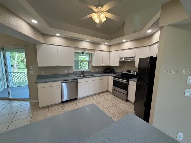 a kitchen with stainless steel appliances kitchen island granite countertop a refrigerator a sink a stove a microwave a counter top and oven