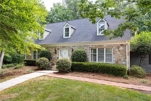a front view of a house with a yard and potted plants