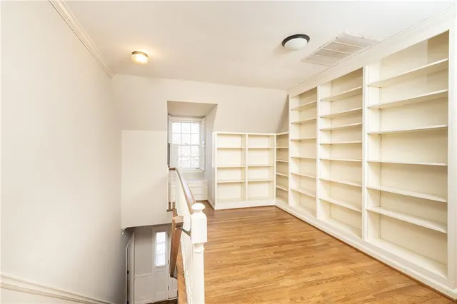 a view of empty room with wooden floor and cabinet