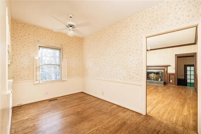 an empty room with wooden floor cabinet and windows