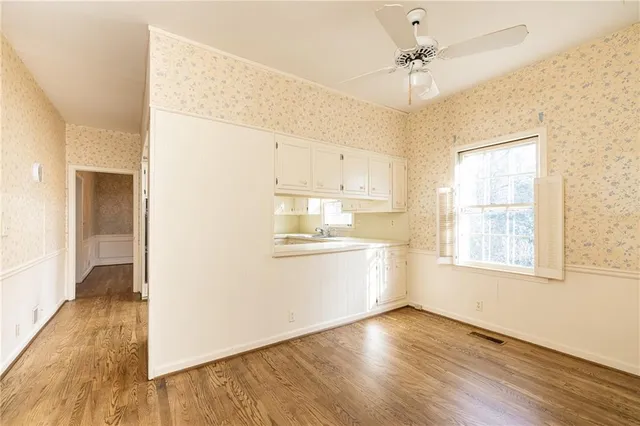 a view of a kitchen with wooden floor and a window