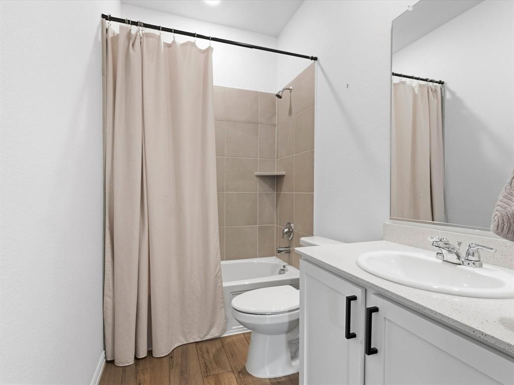 16936 Post Cedar Drive Justin, TX 76247 - Photo 20 of 30 Bathroom featuring wood-finish flooring, a white vanity with a light-toned countertop, and an integrated sink with a chrome faucet