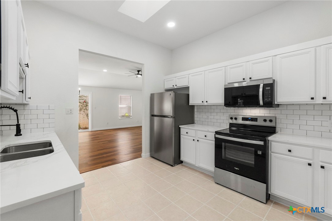 1751 Joy Spring New Braunfels, TX 78130 - Photo 12 of 35 a kitchen with stainless steel appliances granite countertop a stove a refrigerator and a sink