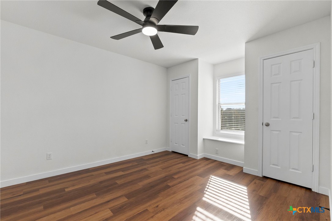 1751 Joy Spring New Braunfels, TX 78130 - Photo 19 of 35 an empty room with wooden floor and windows
