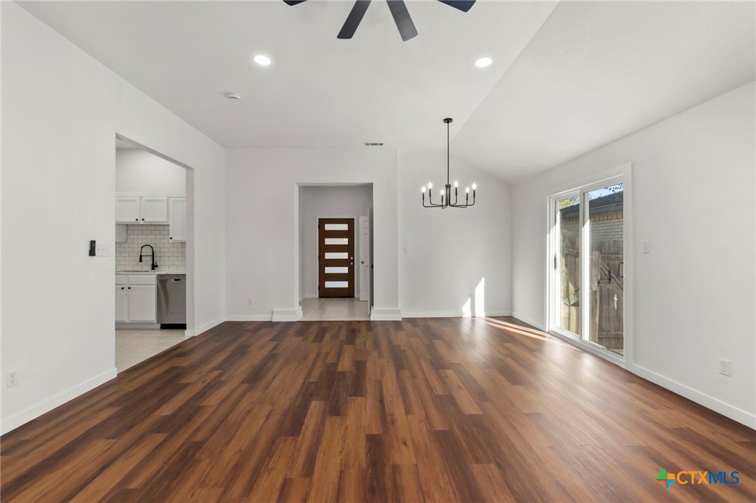 1751 Joy Spring New Braunfels, TX 78130 - Photo 6 of 35 a view of an empty room with a window and wooden floor