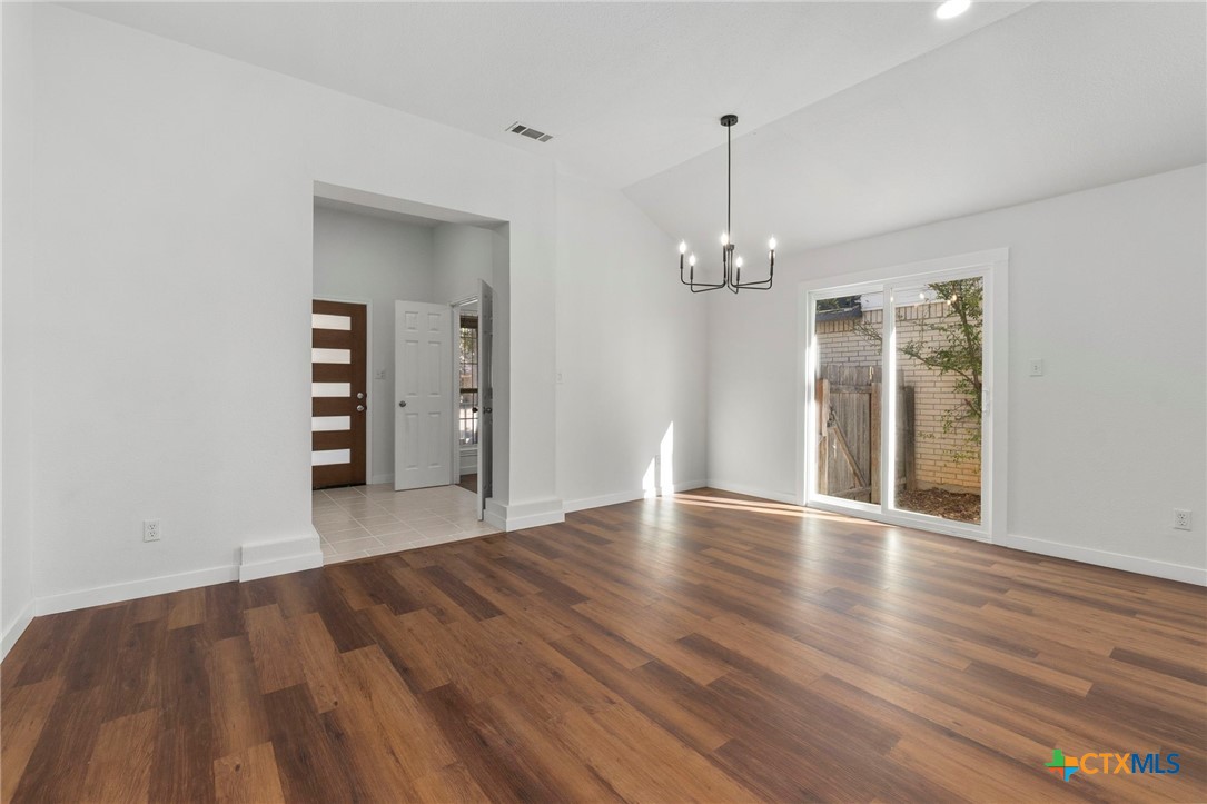 1751 Joy Spring New Braunfels, TX 78130 - Photo 8 of 35 a view of a room with wooden floor chandelier and windows