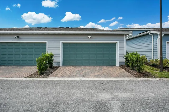 a view of a house with a yard and potted plants