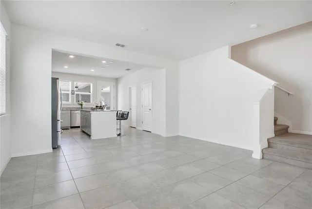 a view of a kitchen with refrigerator and white cabinets