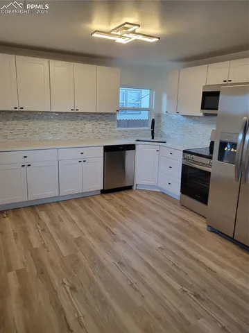 a kitchen with granite countertop a stove cabinets and wooden floor