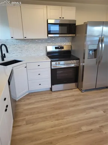 a kitchen with stainless steel appliances kitchen island granite countertop a stove and a refrigerator