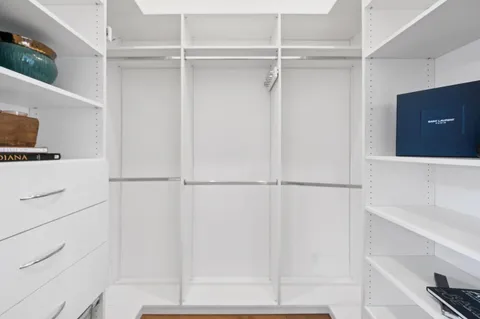 a view of a hallway with wooden floor and closet