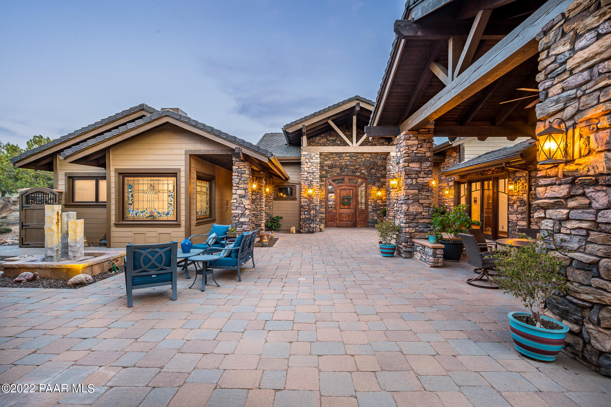 a view of a house with patio furniture and potted plants