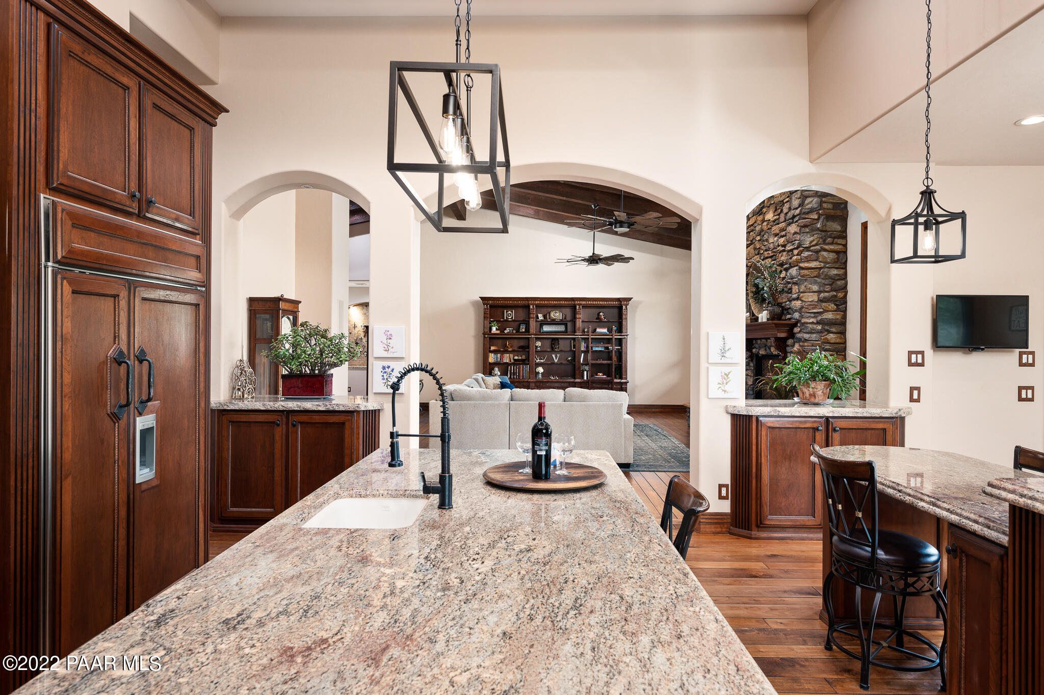 5350 West Three Forks Road Prescott, AZ 86305 - Photo 26 of 90 a kitchen with stainless steel appliances kitchen island granite countertop a refrigerator a stove a sink dishwasher and wooden cabinets with wooden floor