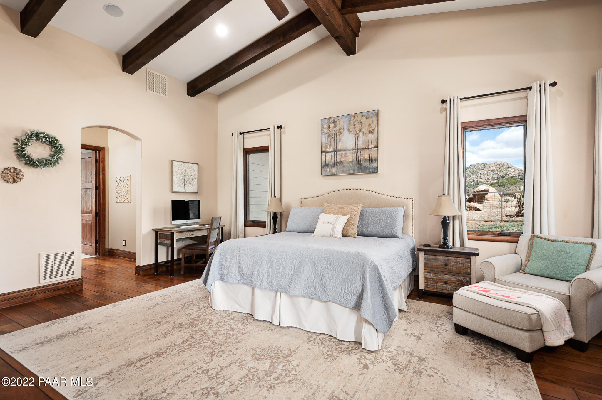 5350 West Three Forks Road Prescott, AZ 86305 - Photo 34 of 90 a spacious bedroom with a bed a couch and a dresser with wooden floor