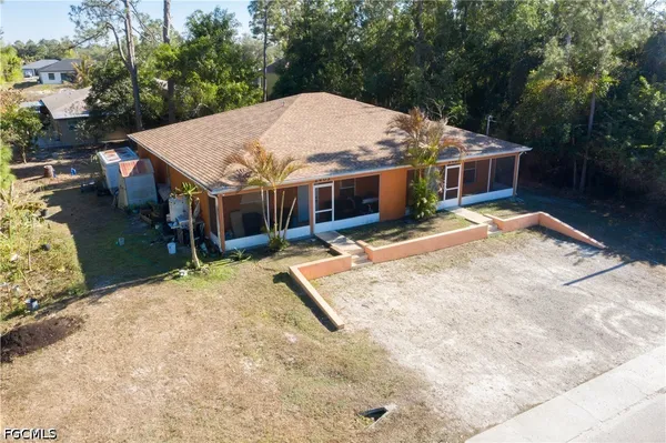 a view of a house with a yard and large tree