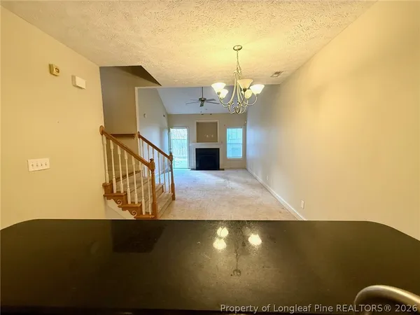 a view of an empty room with a fireplace and a window