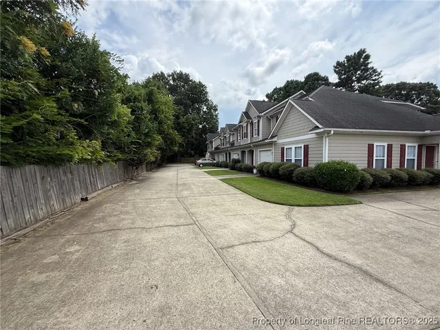 a view of a house with a yard and large tree