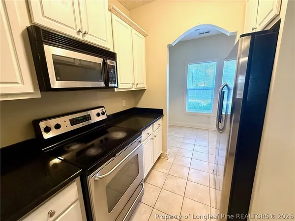 a kitchen with stainless steel appliances granite countertop a sink a stove a refrigerator a washer and dryer