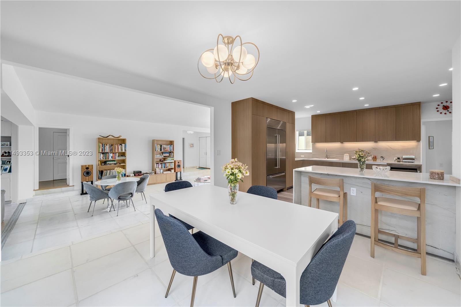 1277 Biscaya Drive Surfside, FL 33154 - Photo 5 of 13 a kitchen with a dining table chairs refrigerator and cabinets