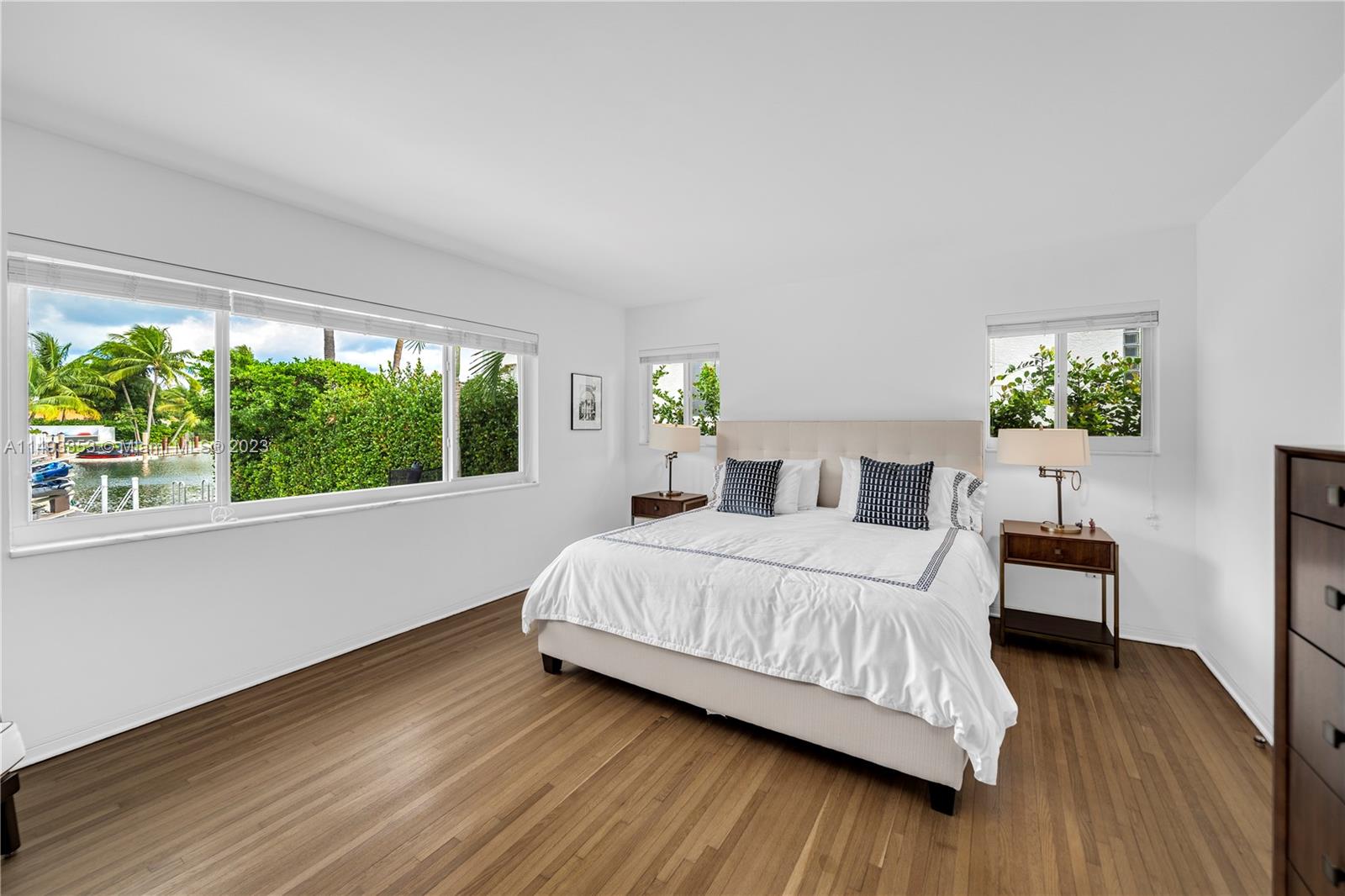 1277 Biscaya Drive Surfside, FL 33154 - Photo 9 of 13 a bedroom with a bed table flowerpot and window