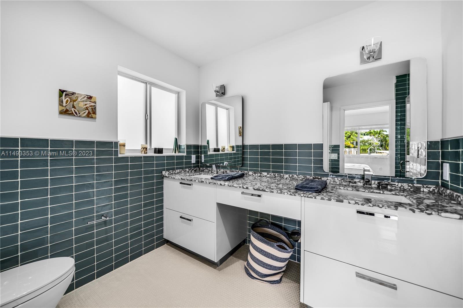 1277 Biscaya Drive Surfside, FL 33154 - Photo 10 of 13 a bathroom with a sink a toilet and mirror