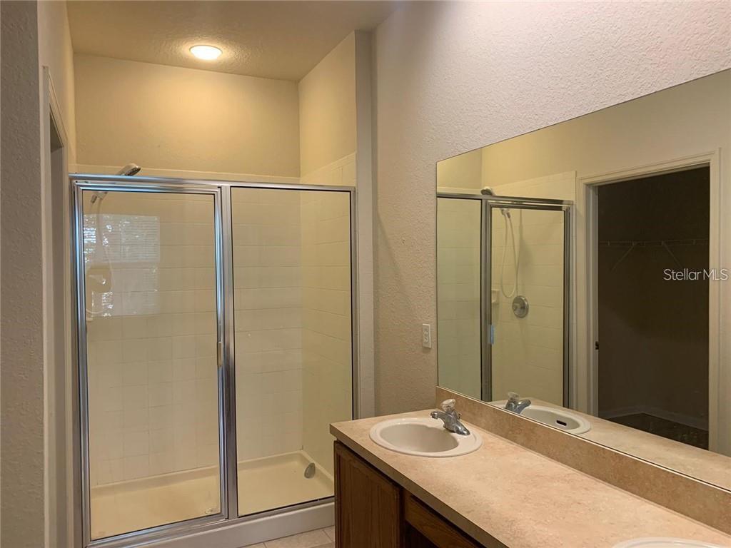 3341 Whitestone Circle, Unit 204 Kissimmee, FL 34741 - Photo 12 of 14 a bathroom with a granite countertop sink and a mirror