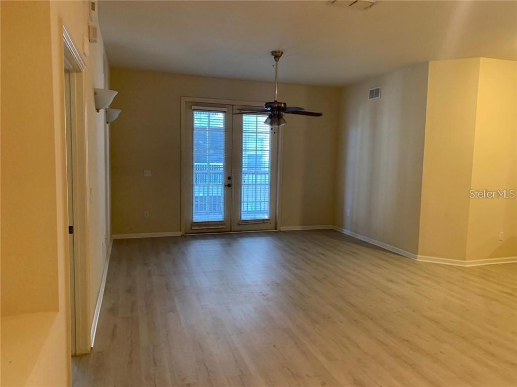 3341 Whitestone Circle, Unit 204 Kissimmee, FL 34741 - Photo 6 of 14 an empty room with wooden floor and windows