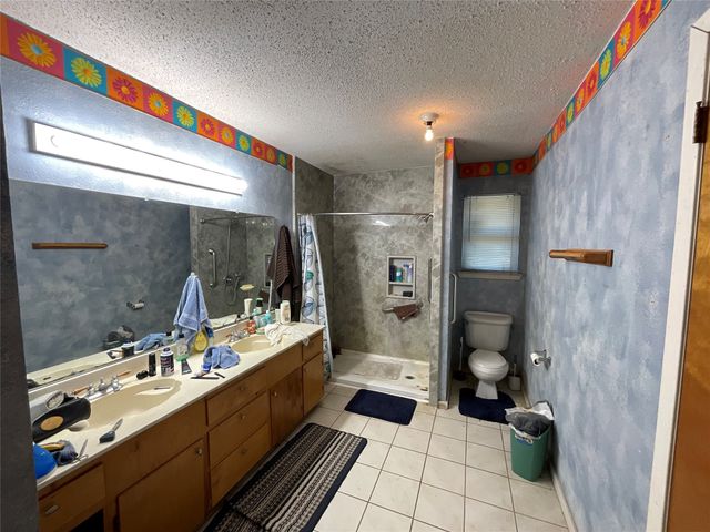 a bathroom with a double vanity sink toilet and shower