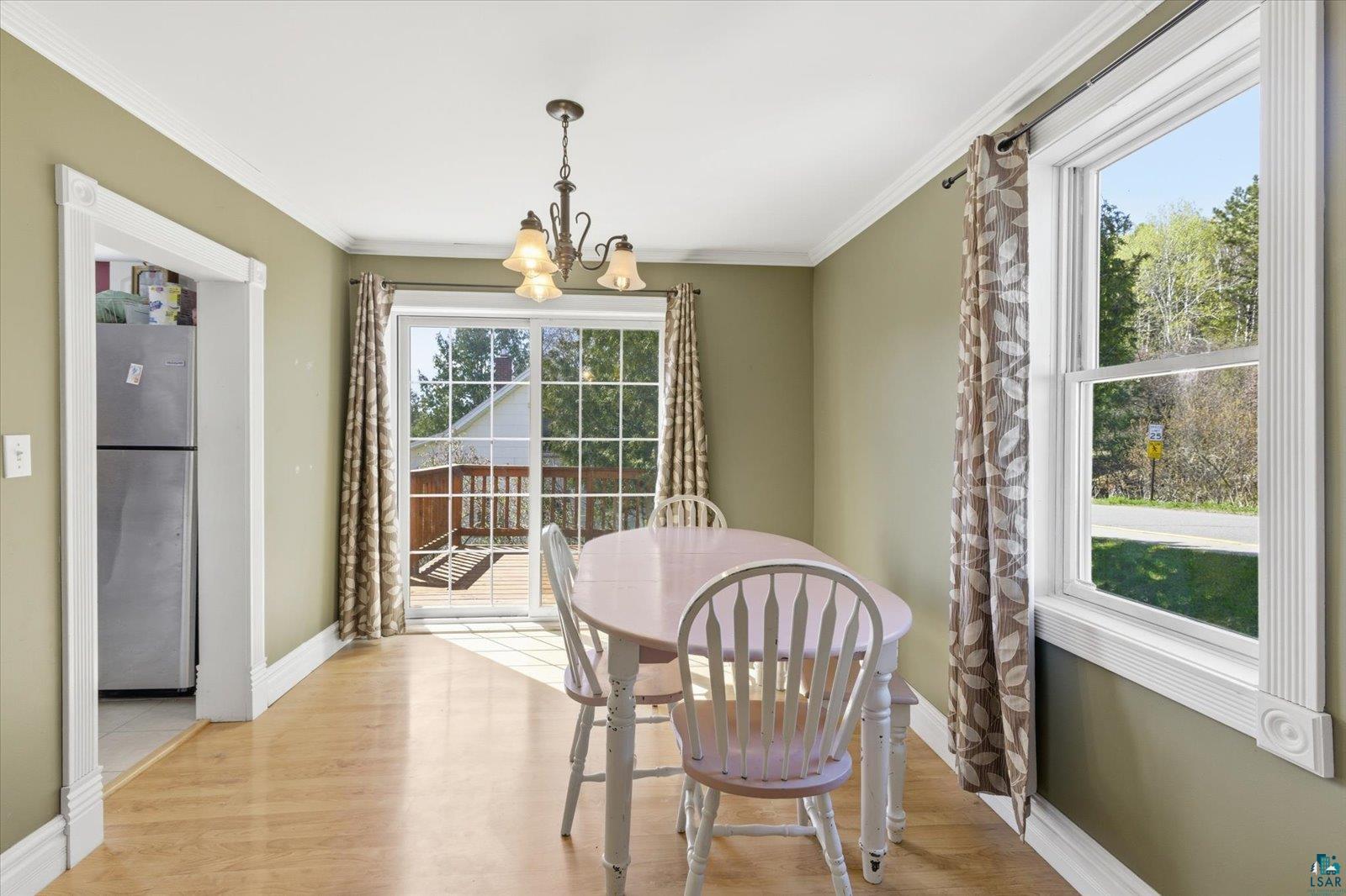 50 Main Street Soudan, MN 55782 - Photo 5 of 31 Dining area featuring wood-finish flooring, crown molding, and sage green walls