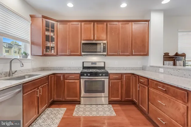 a kitchen with wooden cabinets a sink and a stove top oven