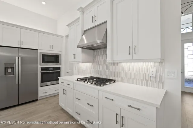 a kitchen with stainless steel appliances a cabinets and a stove top oven